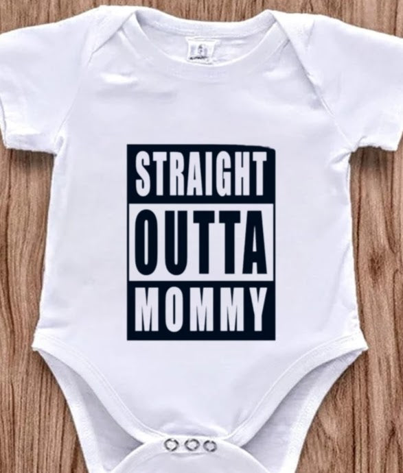 Funny baby onesie with the text 'Straight Outta Mommy' on a wooden background