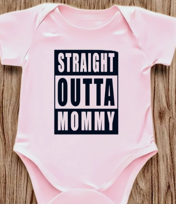 Funny baby onesie with the text 'Straight Outta Mommy' on a wooden background